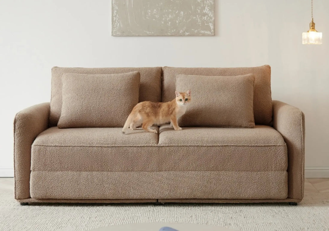 Pet-resistant sofa in tan upholstery with cat standing on seat, showcasing durable fabric design