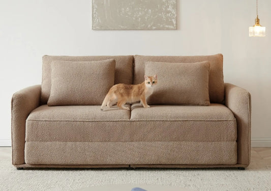 Pet-resistant sofa in tan upholstery with cat standing on seat, showcasing durable fabric design