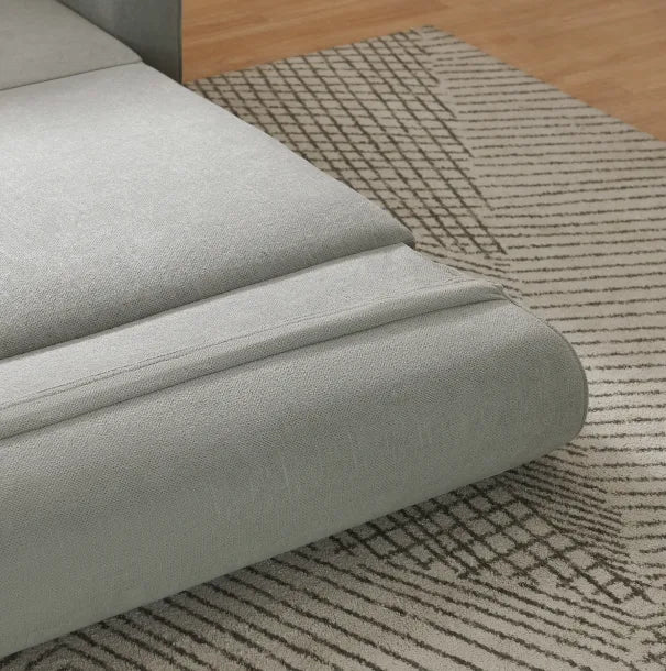 Close-up of light grey woven fabric on the Sunset Sofa Bed over a patterned rug.