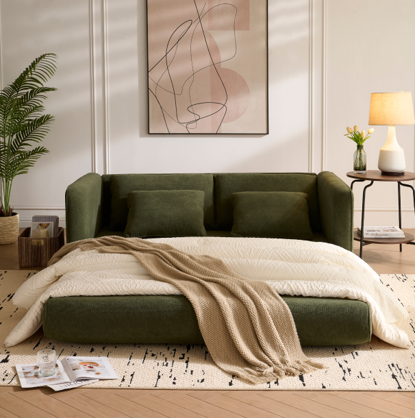 Olive green Sunset Sofa Bed extended flat with cream blanket and pillows in sunlit living room.