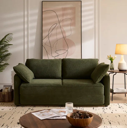 Olive green Sunset Sofa Bed styled in a sunlit living room with abstract art above.
