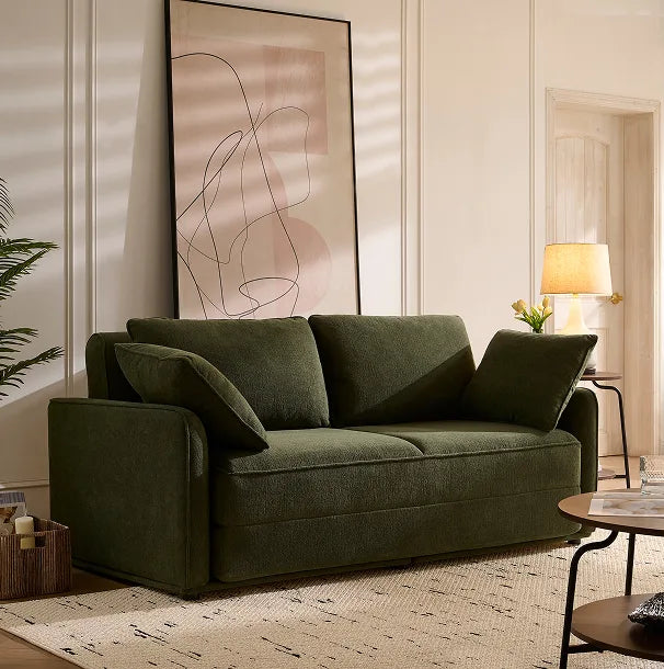 Olive green Sunset Sofa Bed styled in a sunlit living room with abstract wall art.